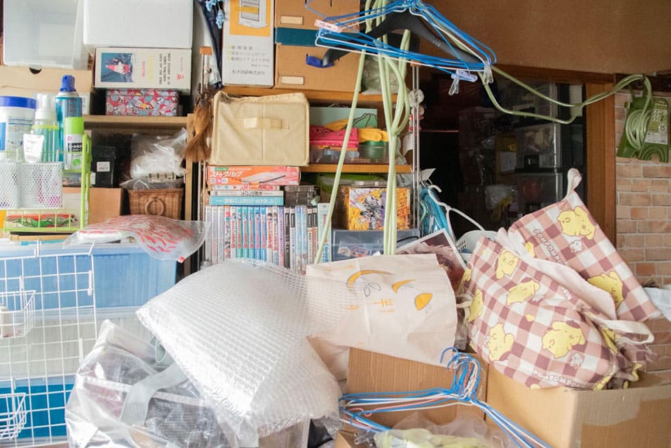 階段の踊り場にある2つの棚は手前の荷物で埋もれてほとんど見えず、取り出しもできない状態